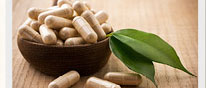 Vitamins in a spoon with a whole leaf