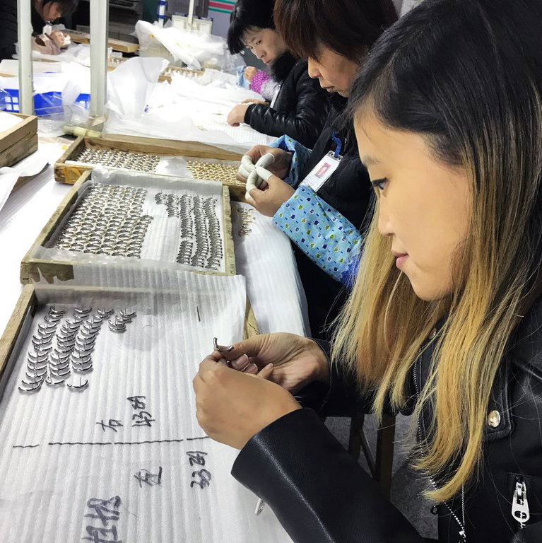 Jen inspecting out Ossie Ear Jackets as part of production