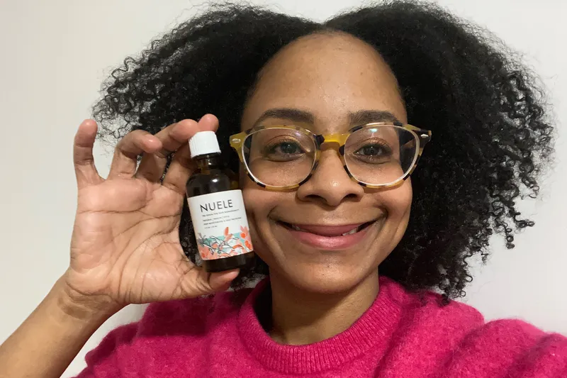 selfie of jihan forbes smiling and holding the Nuele Hair Hair Serum