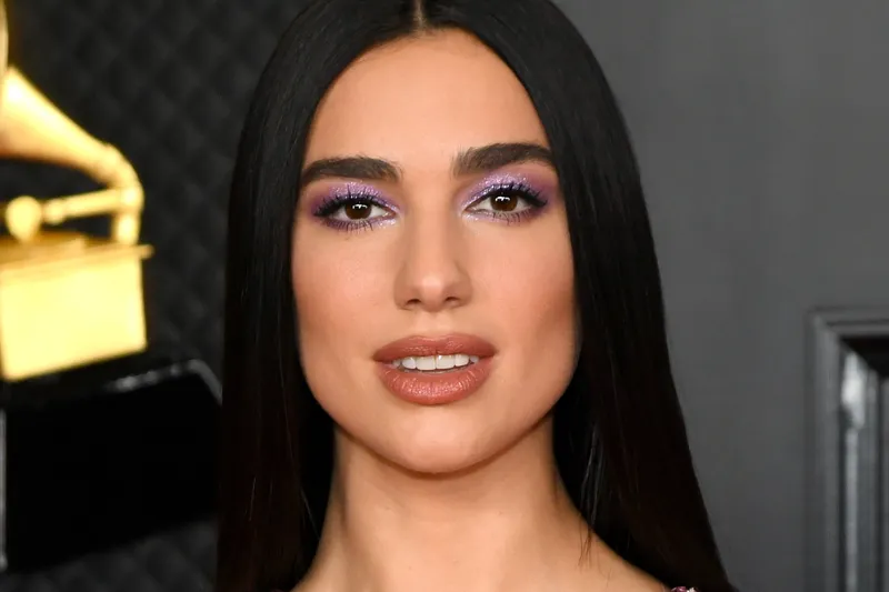 Dua Lipa wearing sleek straight hair and purple sparkly eye shadow at the 2021 Grammys