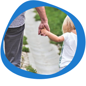 A man holding his daughters hand walking down a path