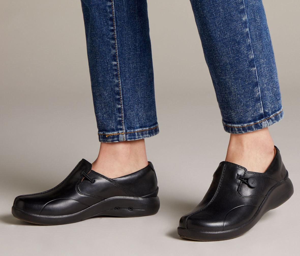 Un Loop 2 Walk in black leather on feet links to product page