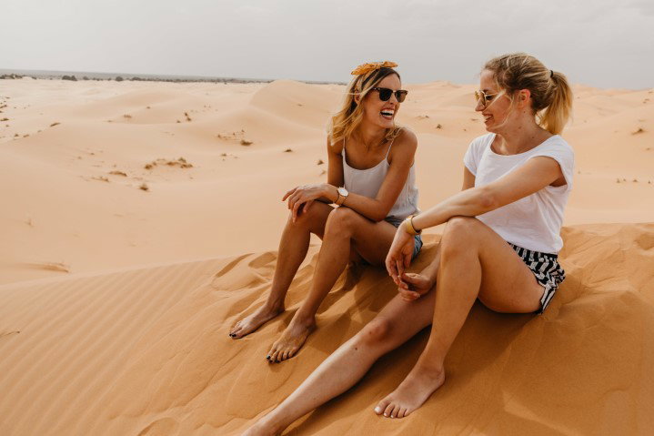 Women smiling in sand dunes Women smiling in sand dunes