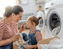 Parent and child taking laundry out and having fun.