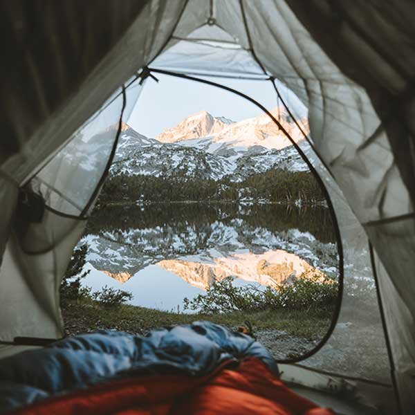 View of a mountain and lake from an open tent door