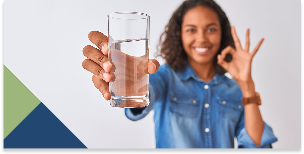 Person holding up glass of water.