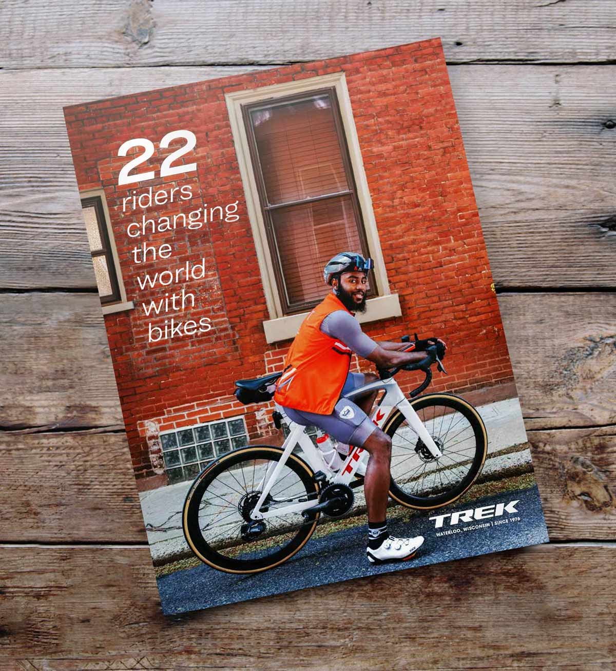 Trek 2021 Summer Quarterly cover which reads '22 riders changing the world with bikes' sitting on a wooden table