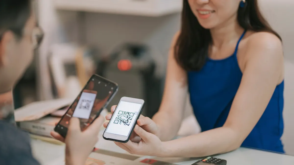 A person receiving payment via QR code on a cell phone.