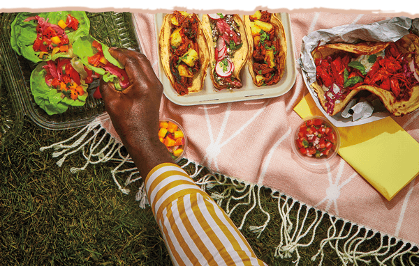 People enjoying takeout tacos at a picnic