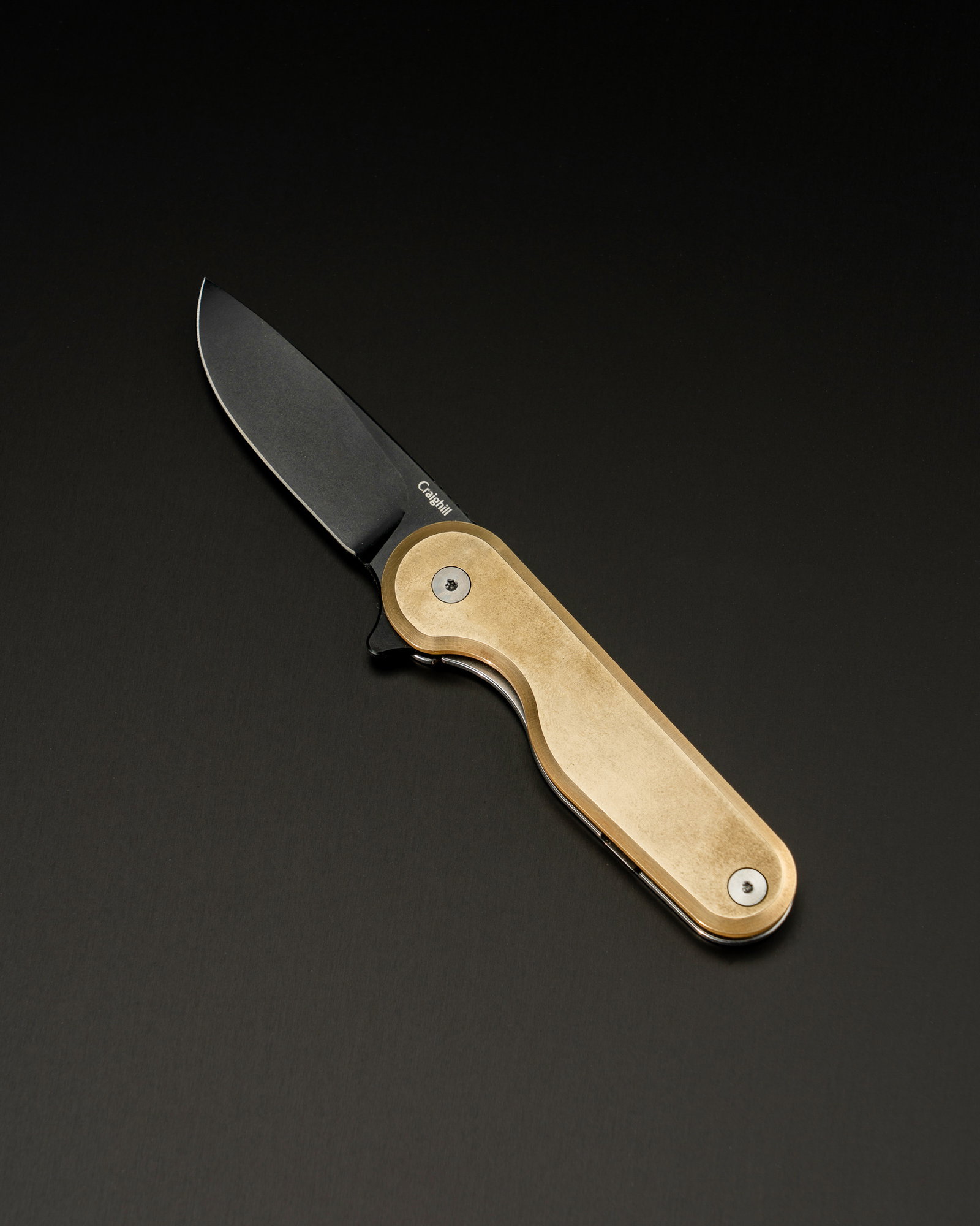 Tricolor Rook Knife on black aluminum surface.