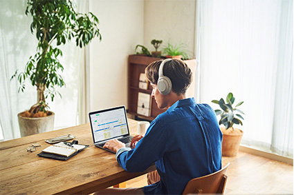 Man using noise cancelling headphones at a desk