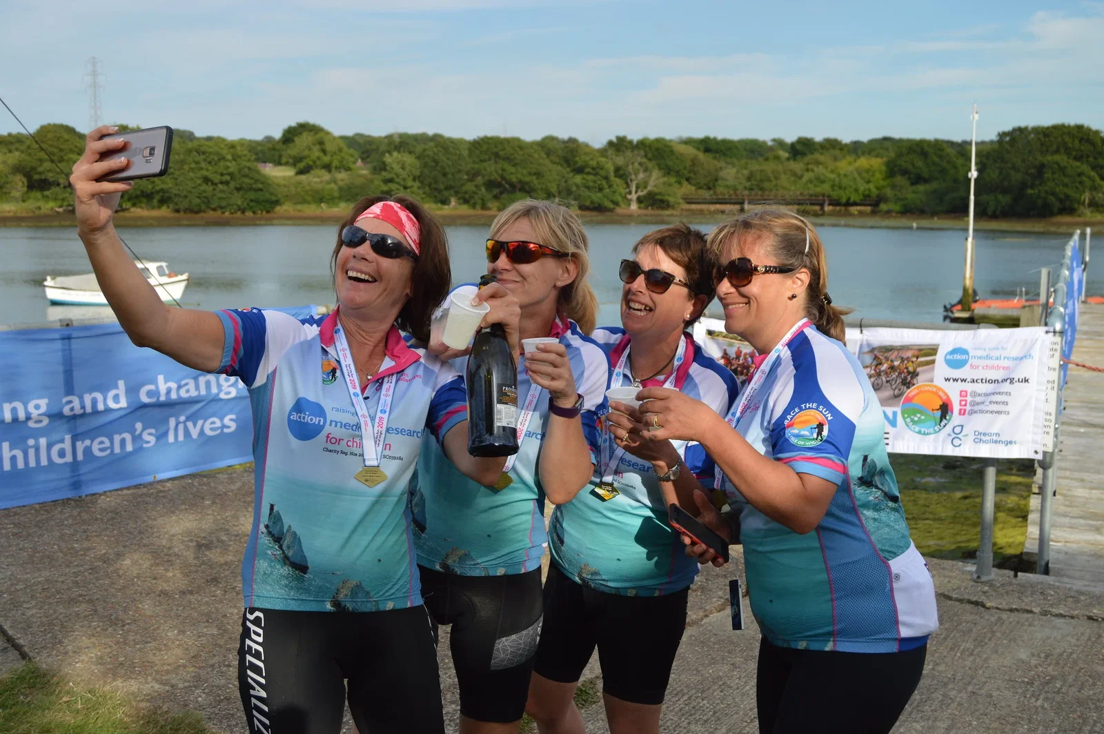 A race the sun team celebrating reaching the finish line with some bubbly and a selfie.
