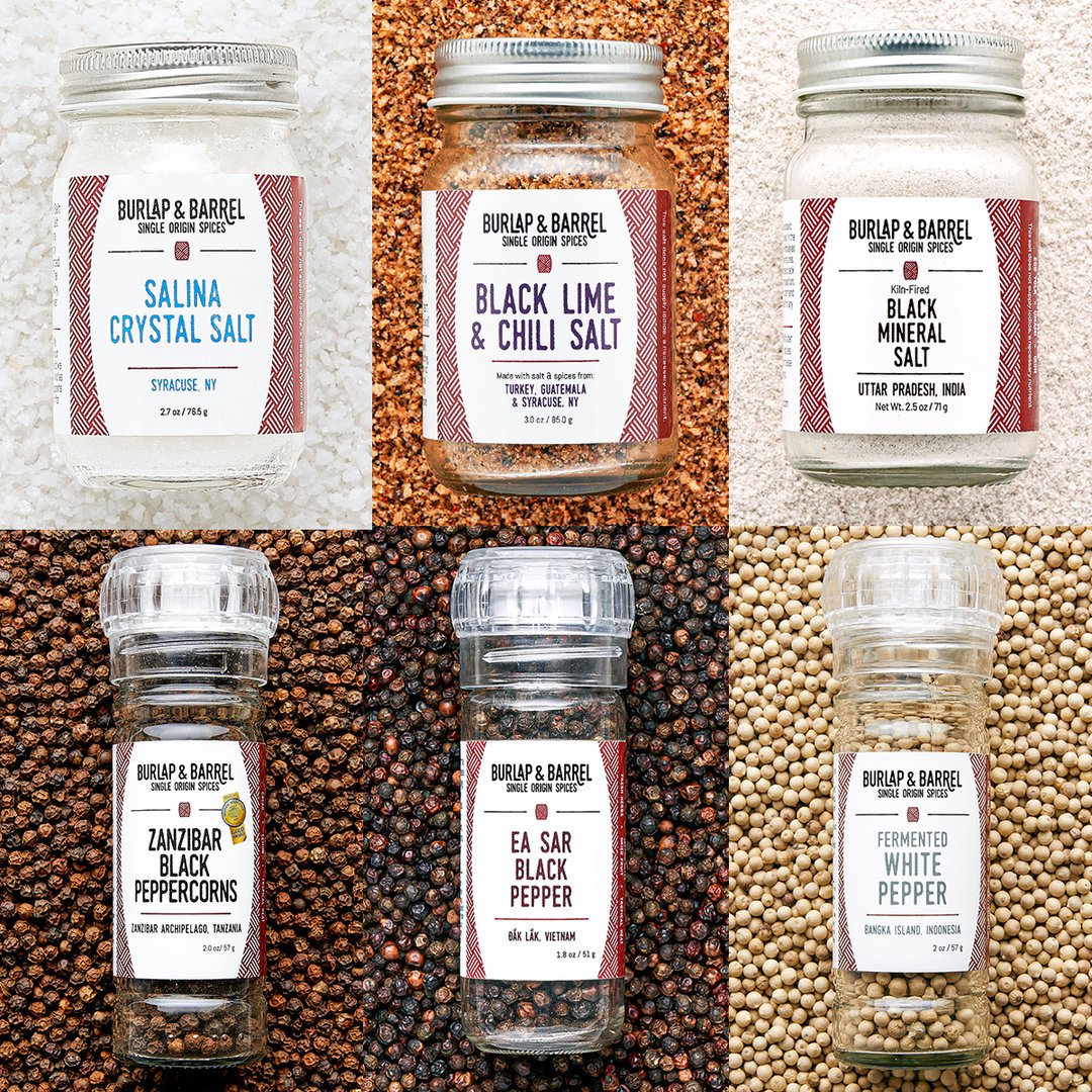 2 by 3 grid of spice jars. three 4 ounce jars of salina cystal salt, black lime & chili salt, and black mineral salt. Three grinder top jars of Zanzibar Black Peppercorns, Ea Sar Black Pepper and Fermented White Pepper