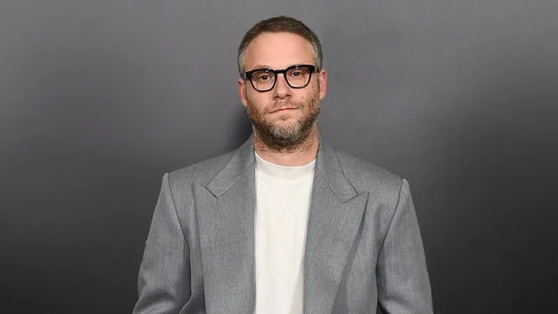 Image may contain: Clothing, Suit, Overcoat, Apparel, Coat, Seth Rogen, Human, and Person