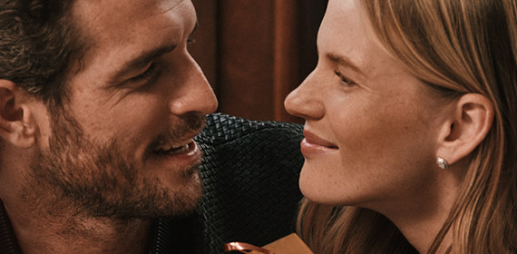 Man and woman smiling at each other while woman holds a small gift box