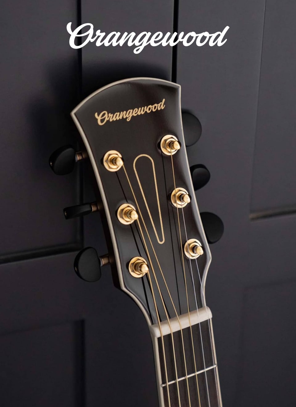 Closeup of orangewood headstock with new logo in a script typeface