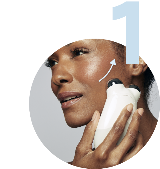 Model gliding the Trinity Device across her middle cheek area.