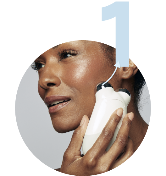 Model gliding the Trinity Device across her middle cheek area.