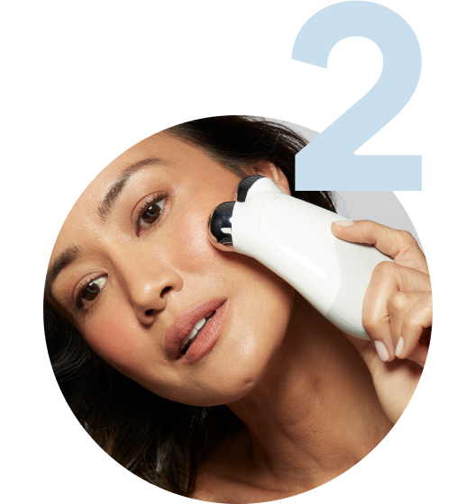 Model holding the Trinity Device on the outer part of her cheekbone