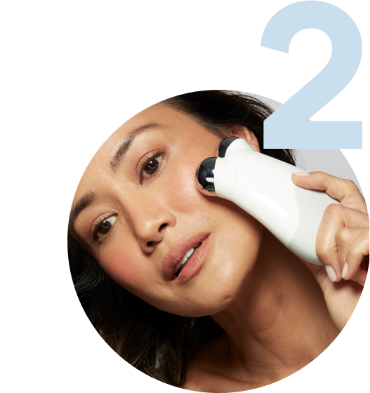 Model holding the Trinity Device on the outer part of her cheekbone
