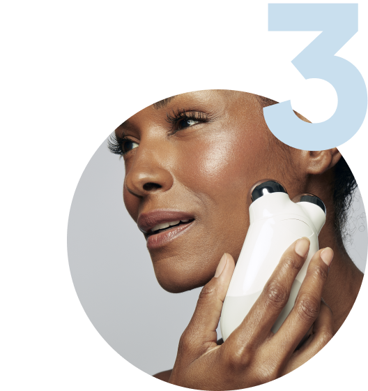 Model using the Trinity Device on her cheekbones to help improve facial contour & tone.