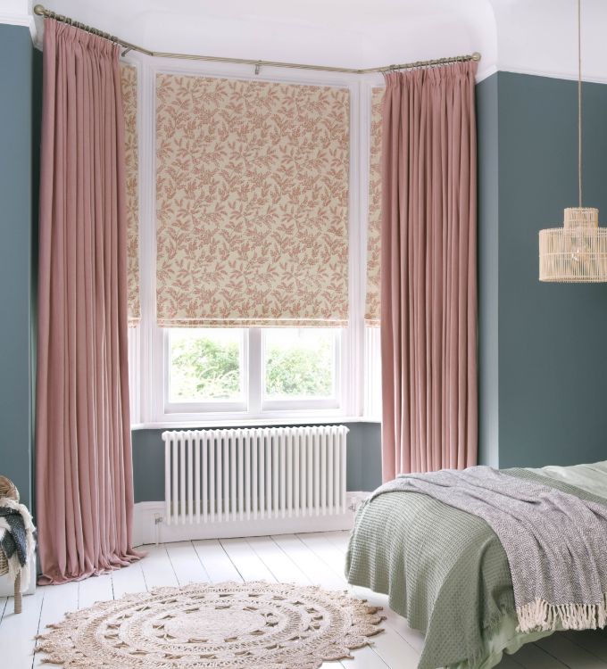 Curtains and Roman blinds in a bay window in a bedroom