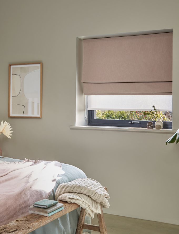 Layered Roman blind and Roller blind in a bedroom