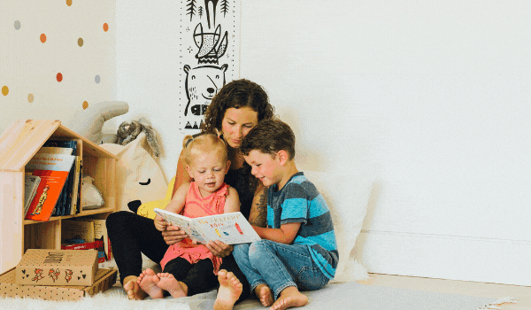 Mom reading a Lillypost book with her two kids.