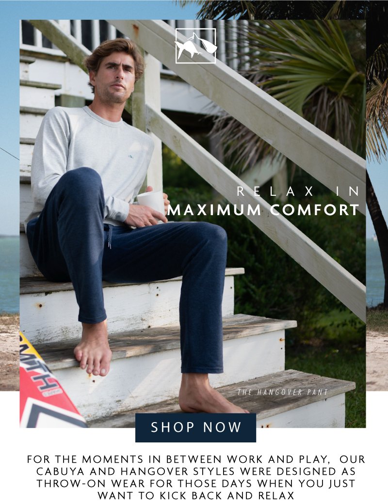 Guy resting on cottage stairs with coffee in fleece pants and crew neck sweat shirt