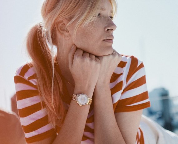 Image of woman outside looking off to the right wearing a Bulova Marine Star Automatic watch