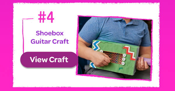 Guy holding completed Shoebox Guitar Craft