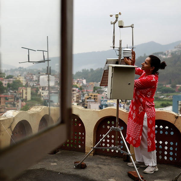 Hemu Kafle checks on one of the low-cost meteorological stations on the roof of the the Kathmandu Institute of Applied Sciences