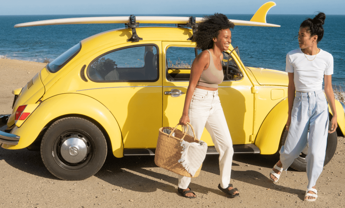 Two woman walking away from yellow car