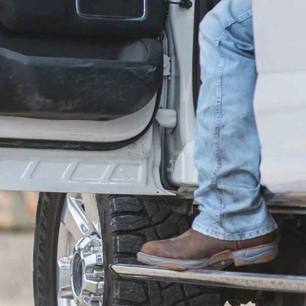 Image of man wearing Tony Lama boots while getting out of truck.