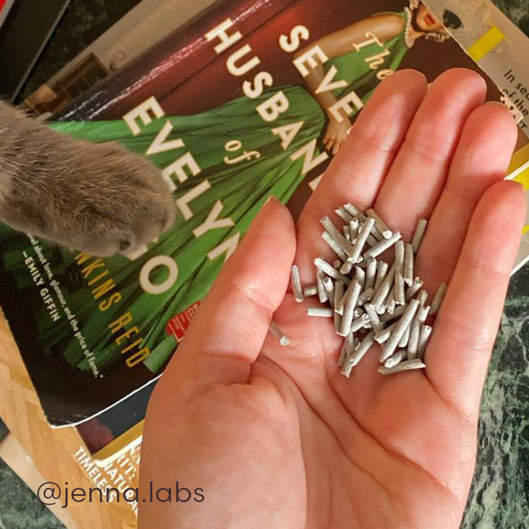Hand holding a small pile of Really Great Cat Litter, showing its unique large pellet shape.