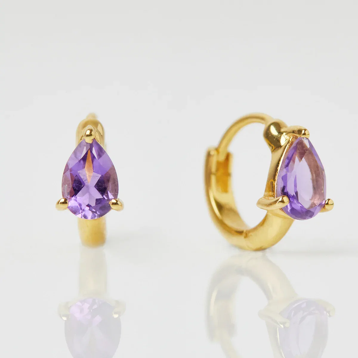 Image of Pear Amethyst Huggie Hoops In Gold Vermeil
