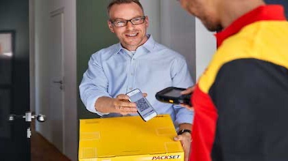Ein Kunde übergibt sein Paket an den DHL Zusteller