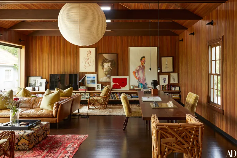 a living room filled with eclectic pieces of furniture and artwork along one wall