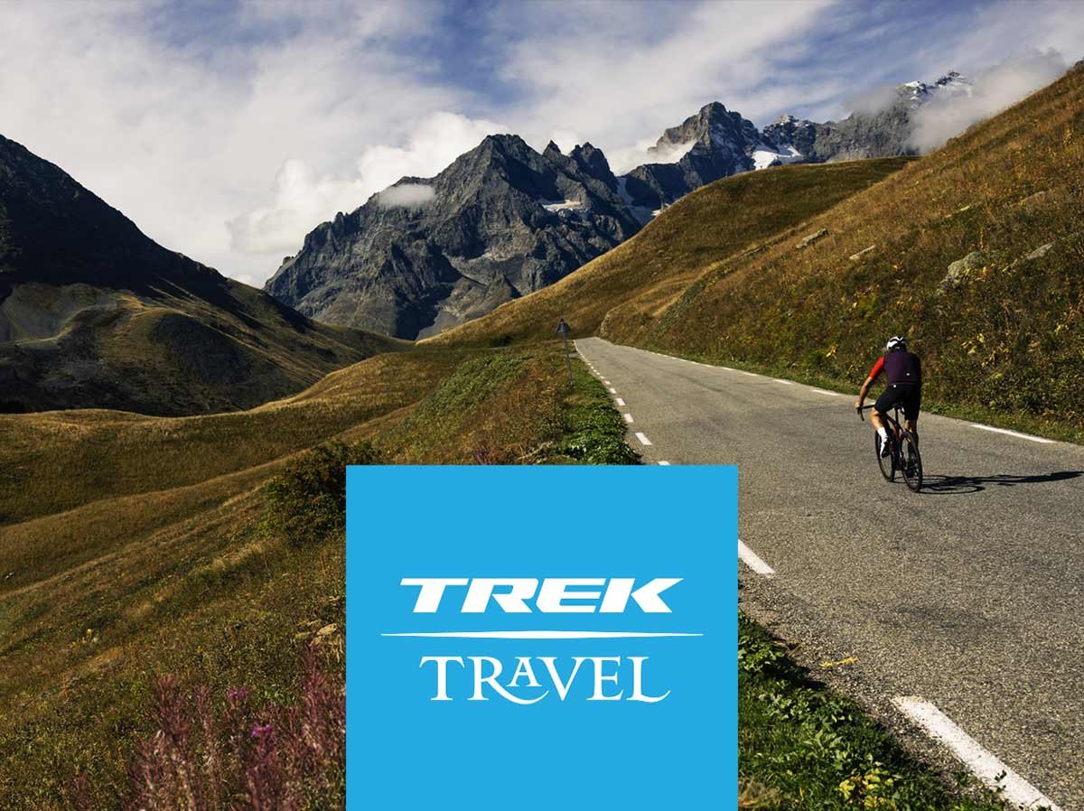 Trek Travel logo overlaying image of cyclist wearing helmet on paved road with mountains in background