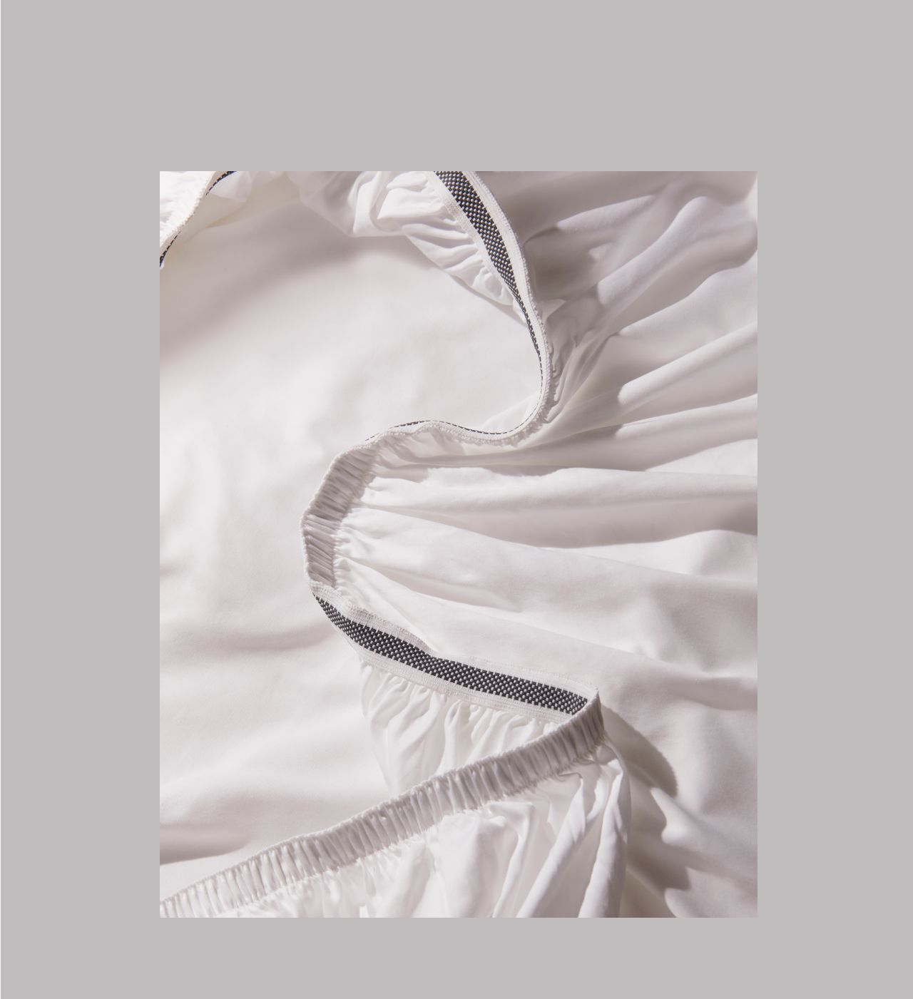 A close up image of a fitted sheet, showing the grippy elastic seam.