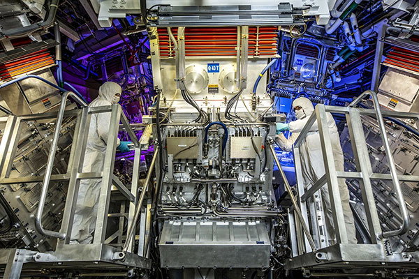 NIF Target Area operators in PPE on a lift, inspect a final optics assembly (FOA) during a routine maintenance period.