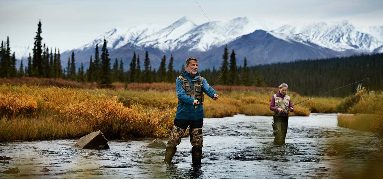 A couple fishing in Alaska river. View 11-Night Alaska Cruisetours now.