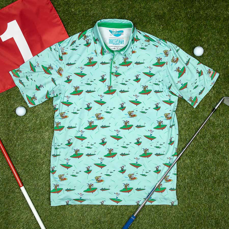 "Orbit City Golf Club" All-Day Polo lying on grass amongst golf equipment.
