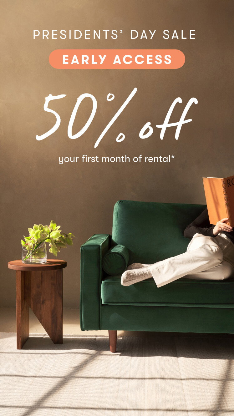Image of woman sitting on the Monroe sofa reading a book, also featuring the Homer side table with a plant on top. Text overlay ''Presidents' Day Sale - Early Access, 50% off your first month of rental'' 