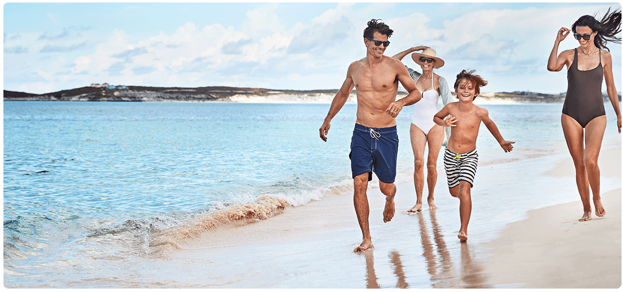 Family of four running on Caribbean beach. View Caribbean cruises.