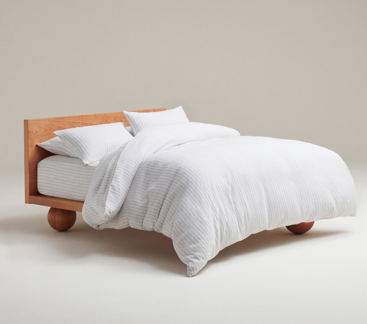 picture of a bed made up in Rise & Fall linen bedding in stripe