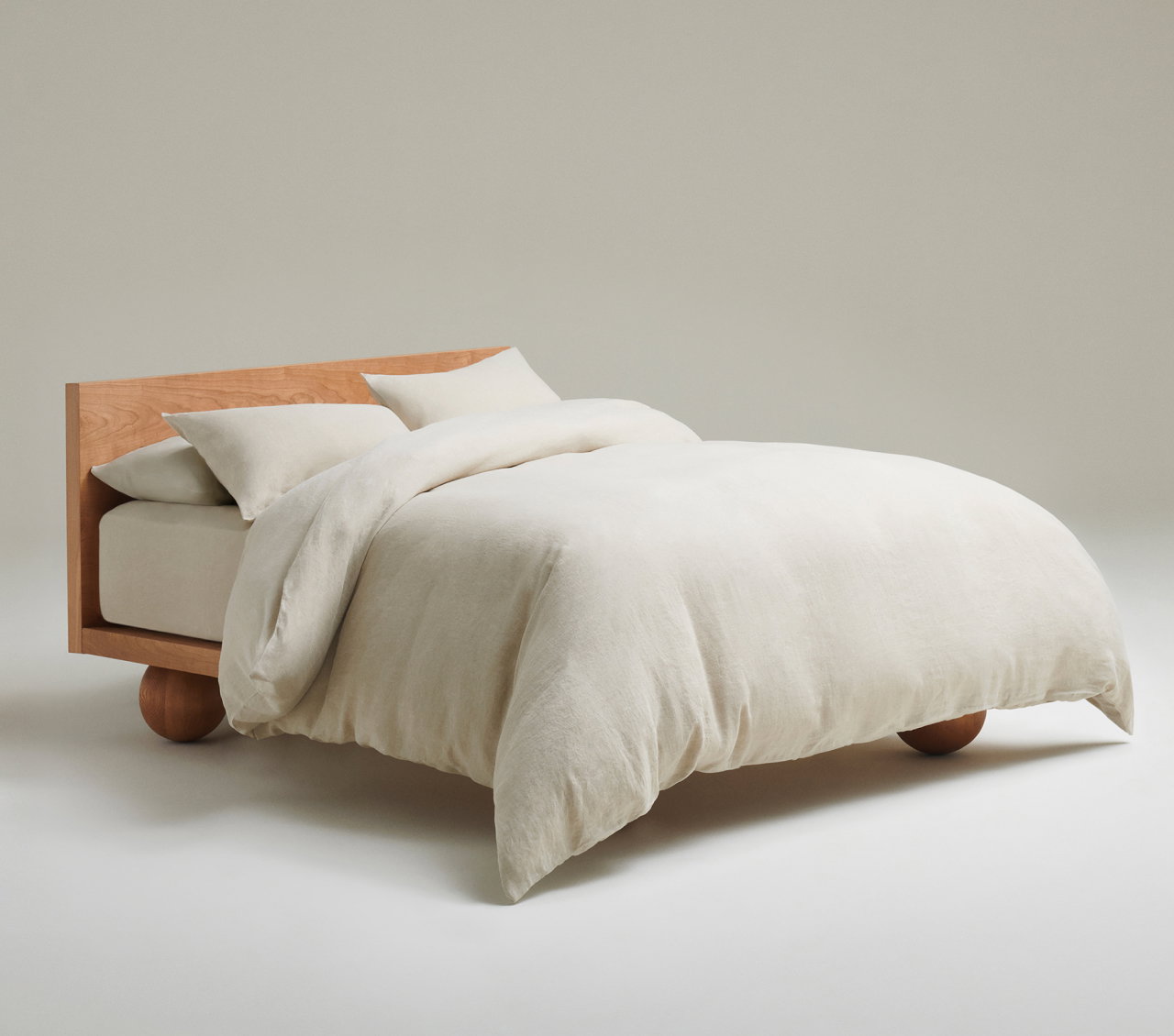 picture of a bed made up in Rise & Fall linen bedding in natural