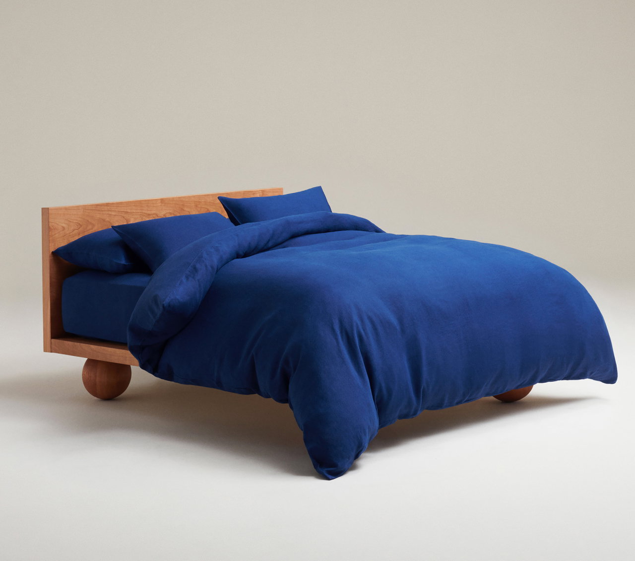 picture of a bed made up in Rise & Fall linen bedding in indigo