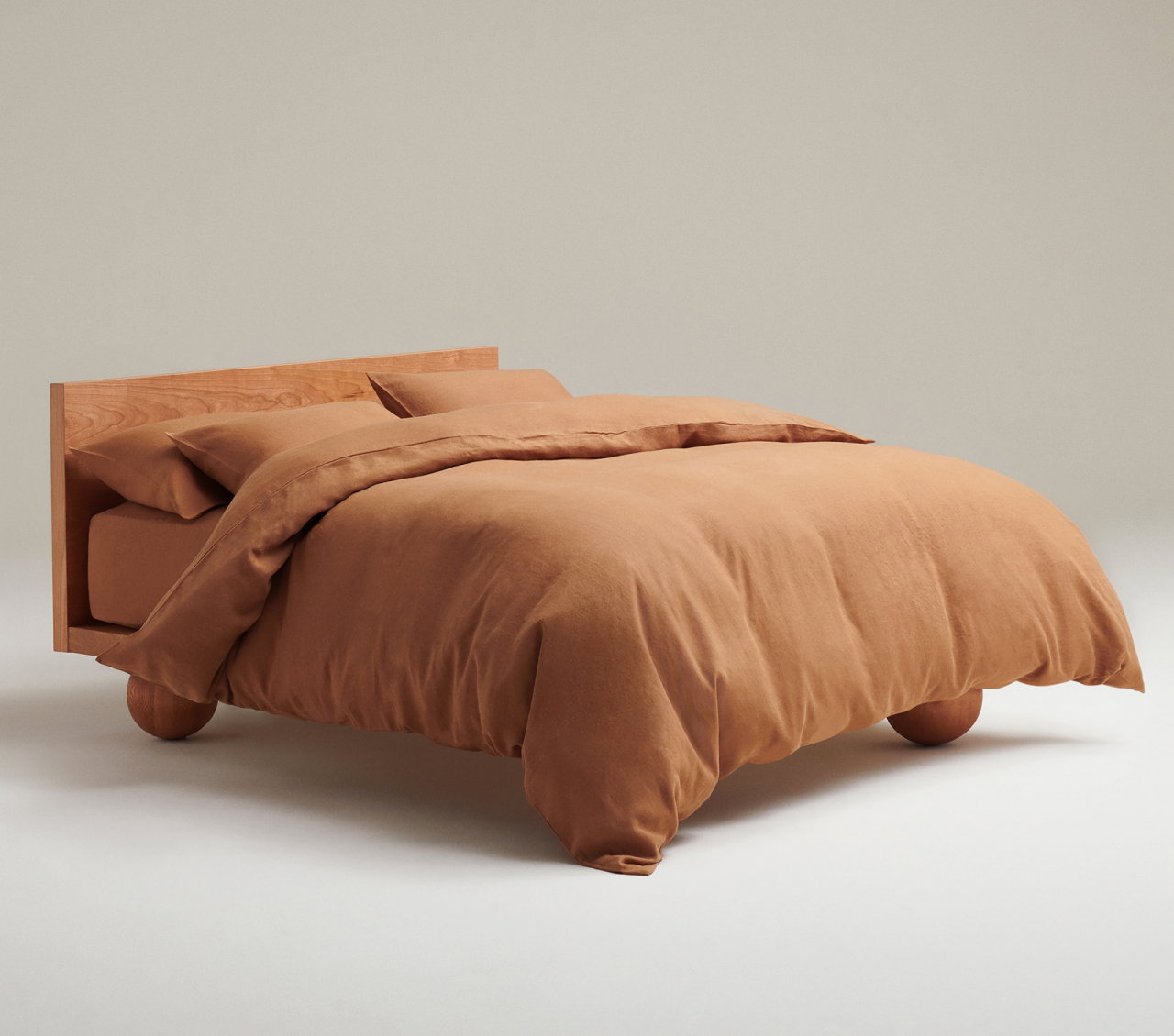picture of a bed made up in Rise & Fall linen bedding in ochre