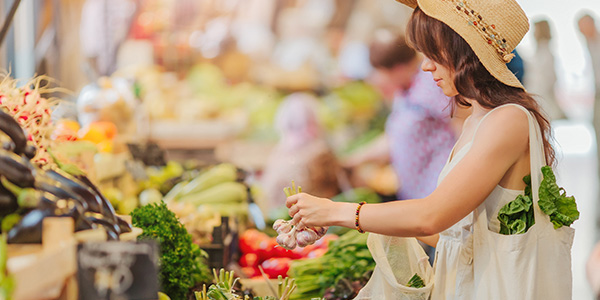 photo of a woman shopping for produce at a market